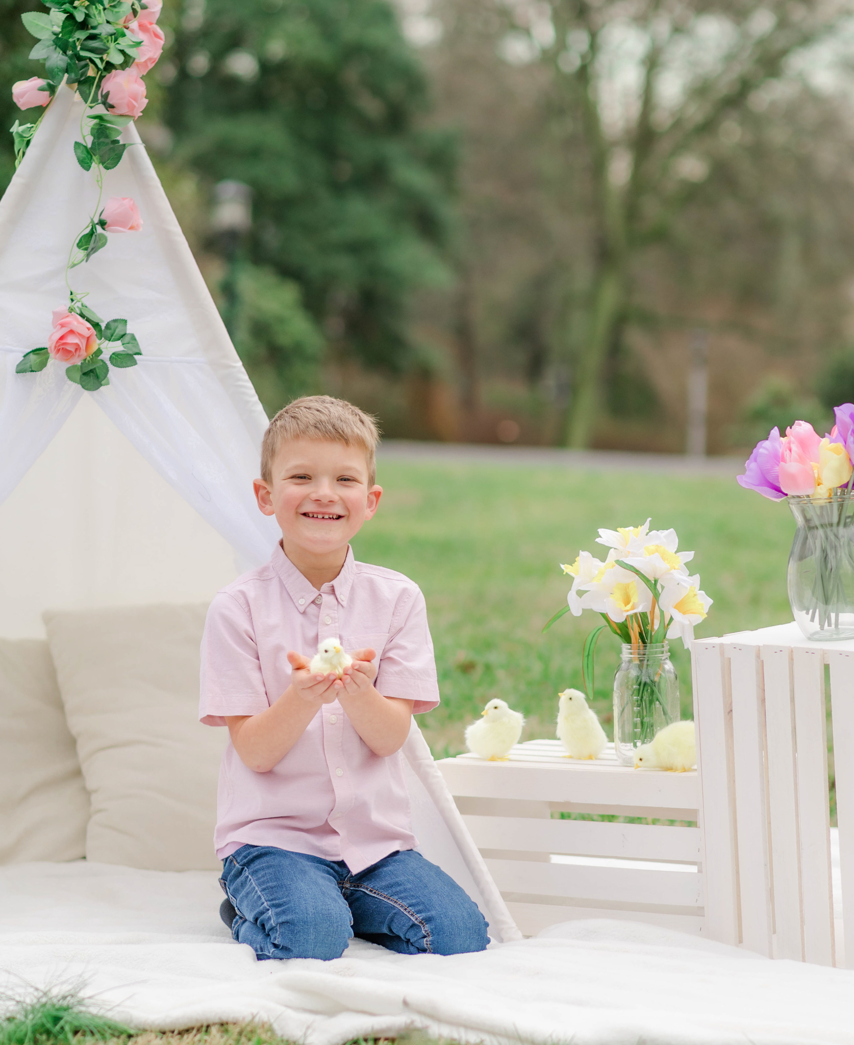 Boy laughs while holding baby chick during spring family photoshoot in Wilmington Delaware